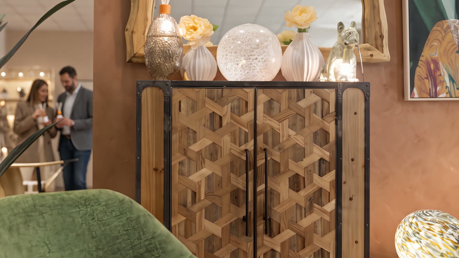 Lo showroom di Genova con parete in terracotta e lampade in vetro, e due buyer che guardano la collezione