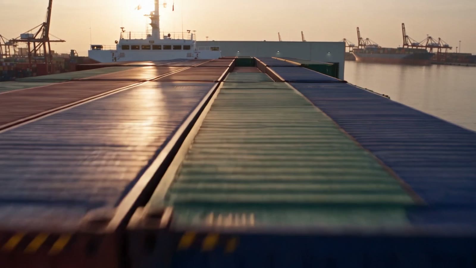 Una nave portacontainer carica, vista dall'alto in un porto al tramonto