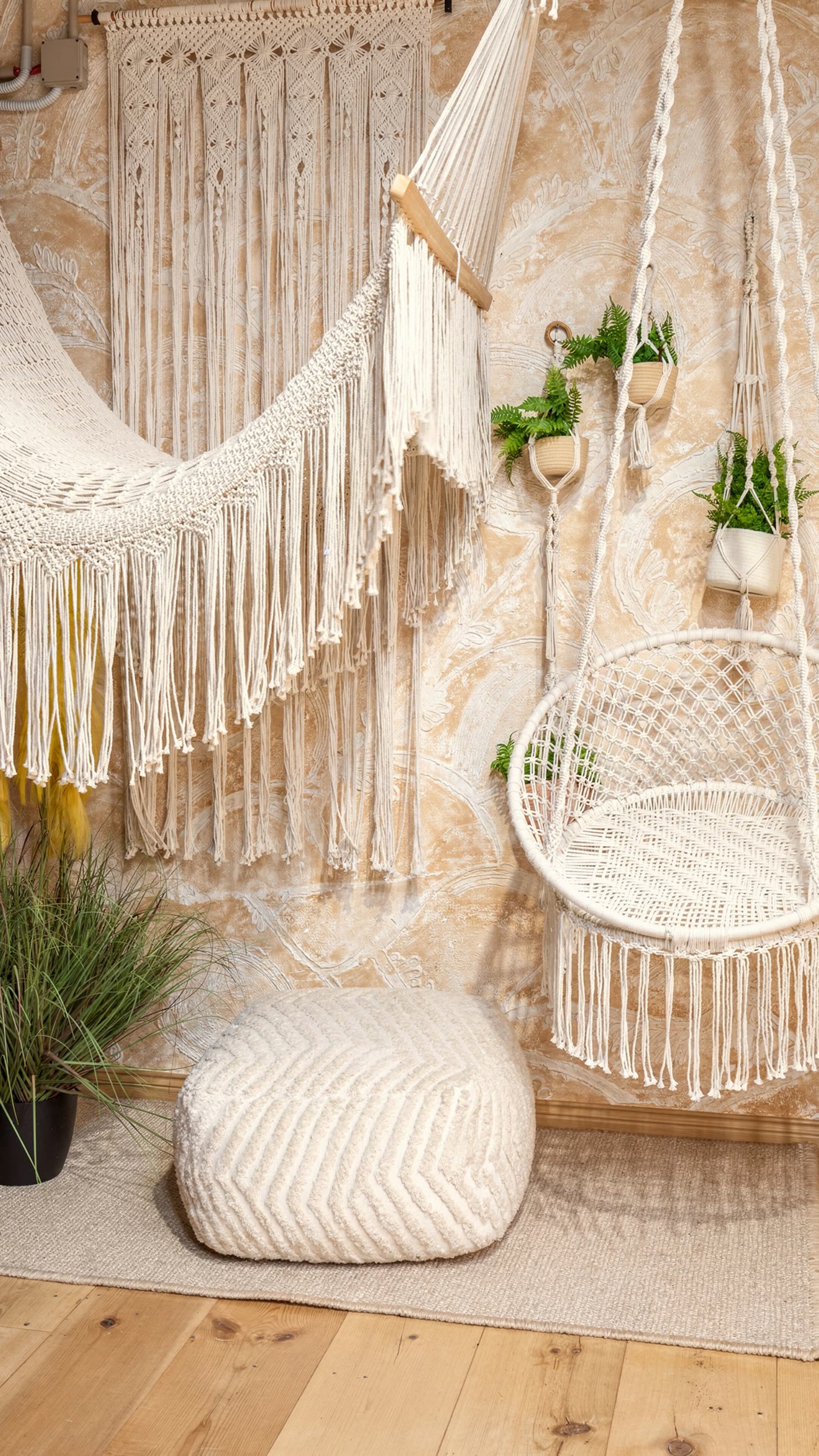 Un’amaca in macramè e un pouf bianco in un angolo dello showroom