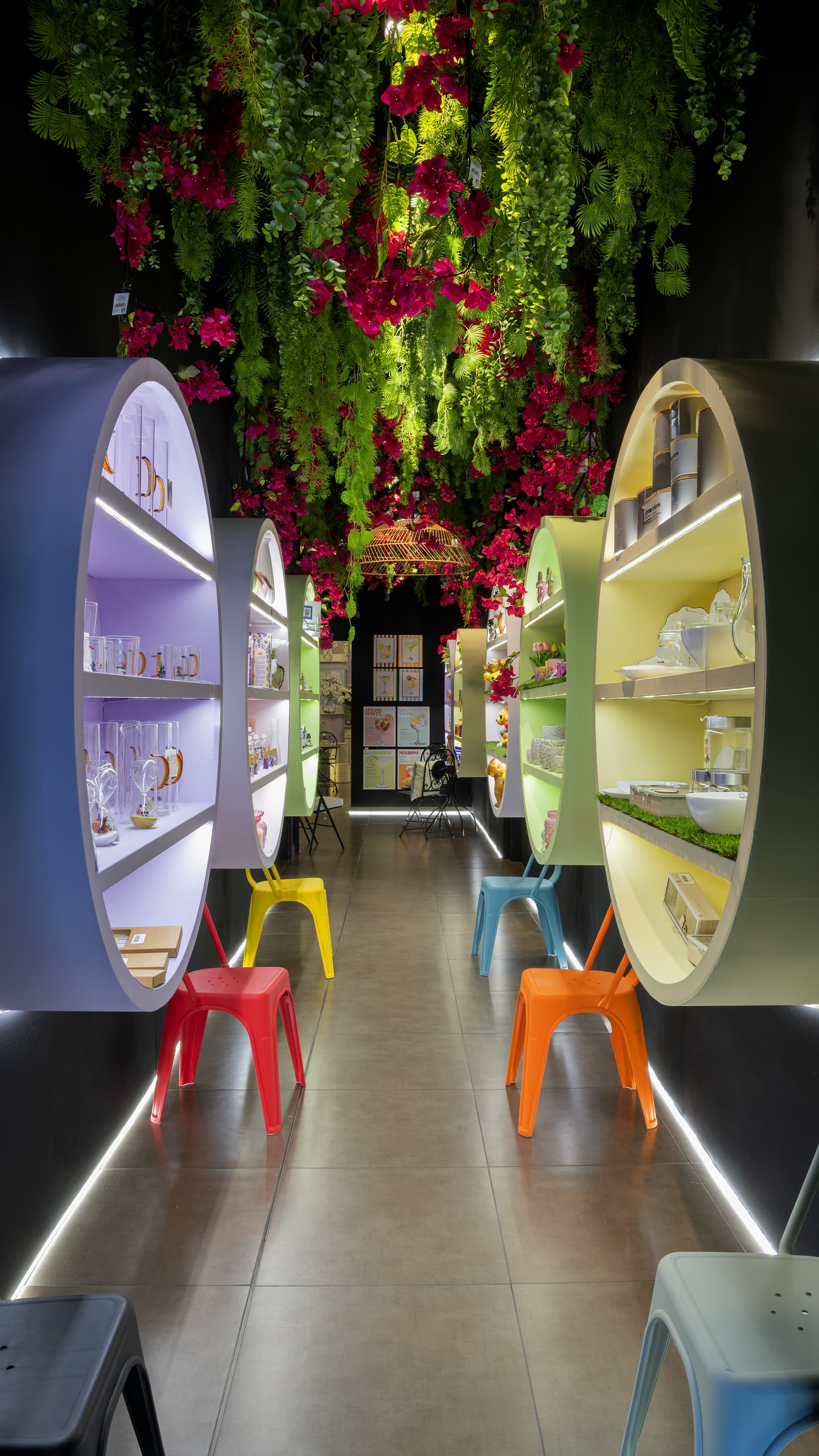 Scaffali curvi colorati e sgabelli lungo un corridoio dello showroom