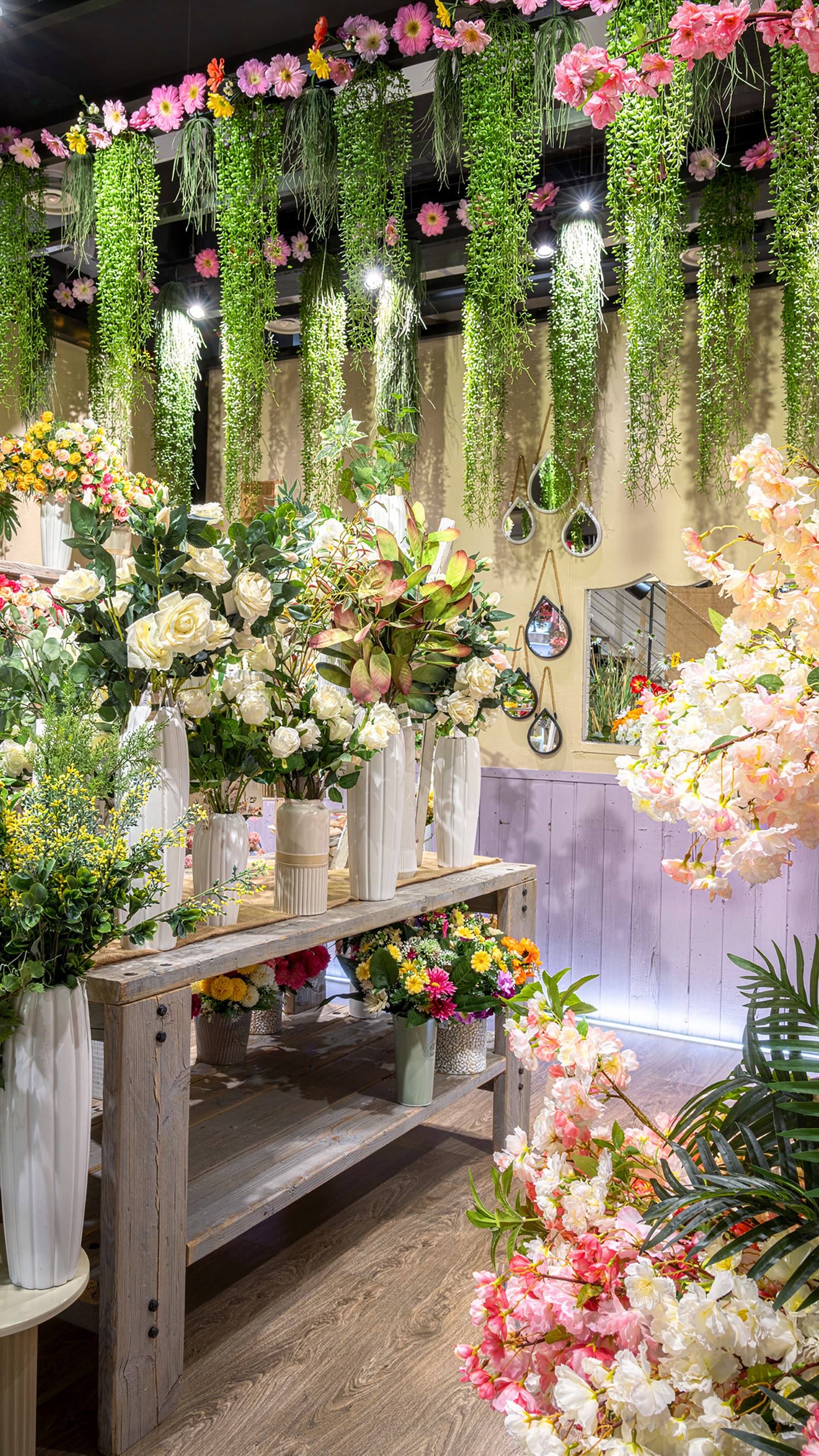 Fiori artificiali su scaffali bianchi nell’allestimento primaverile