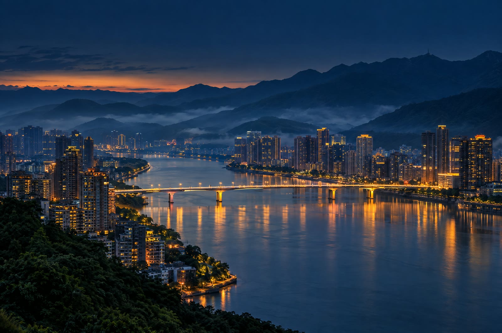 Fuzhou lungo il fiume Min, con un ponte illuminato e le montagne sullo sfondo, all’ora blu