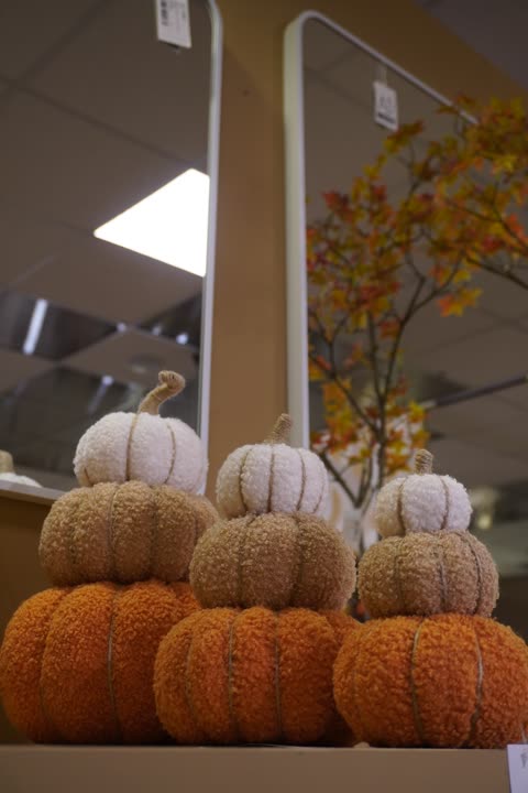 Una pila di zucche decorative in tessuto, arancioni e bianche