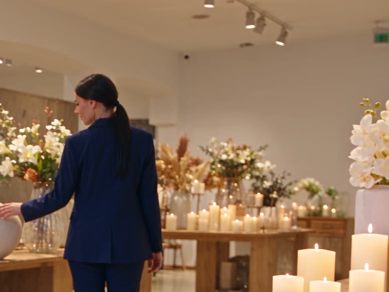 Lo showroom di Genova con candele, fiori secchi e vasi sui tavoli espositivi